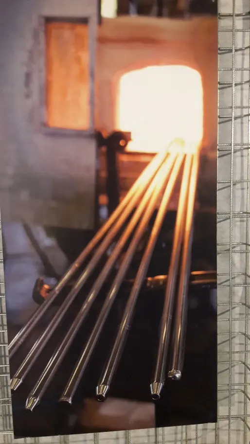 Canne da soffio davanti alla bocca del forno incandescente